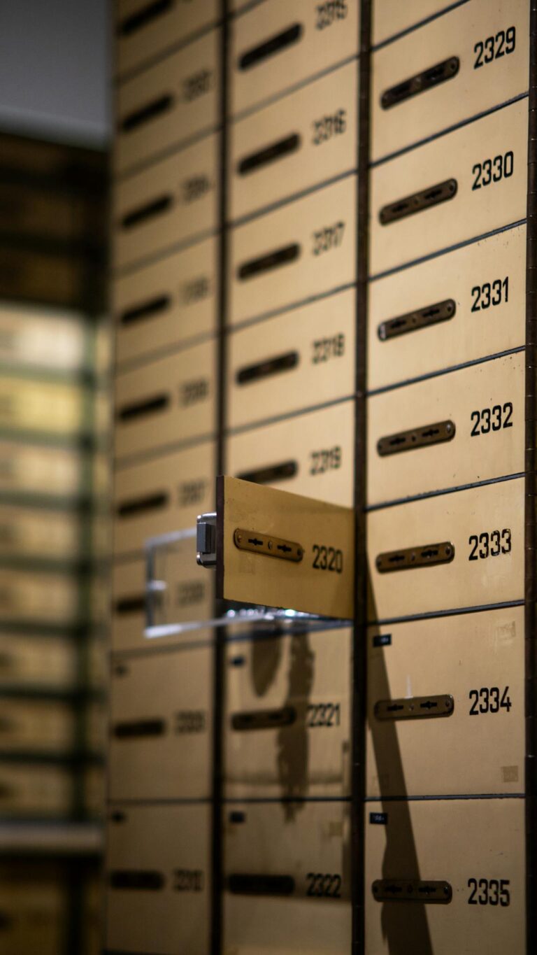Vertical shot of metallic lockboxes with numbers in a bank vault.